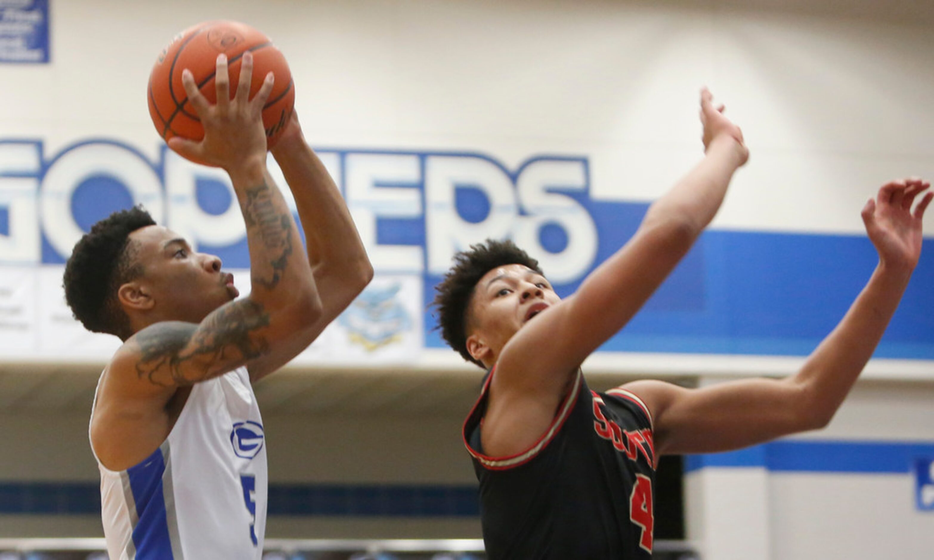 Grand Prairie's Donovan Newton (5) drives to the basket as he is defended by South Grand...