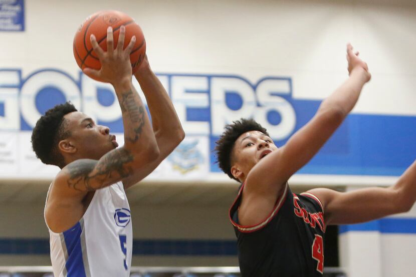 Grand Prairie's Donovan Newton (5) drives to the basket as he is defended by South Grand...