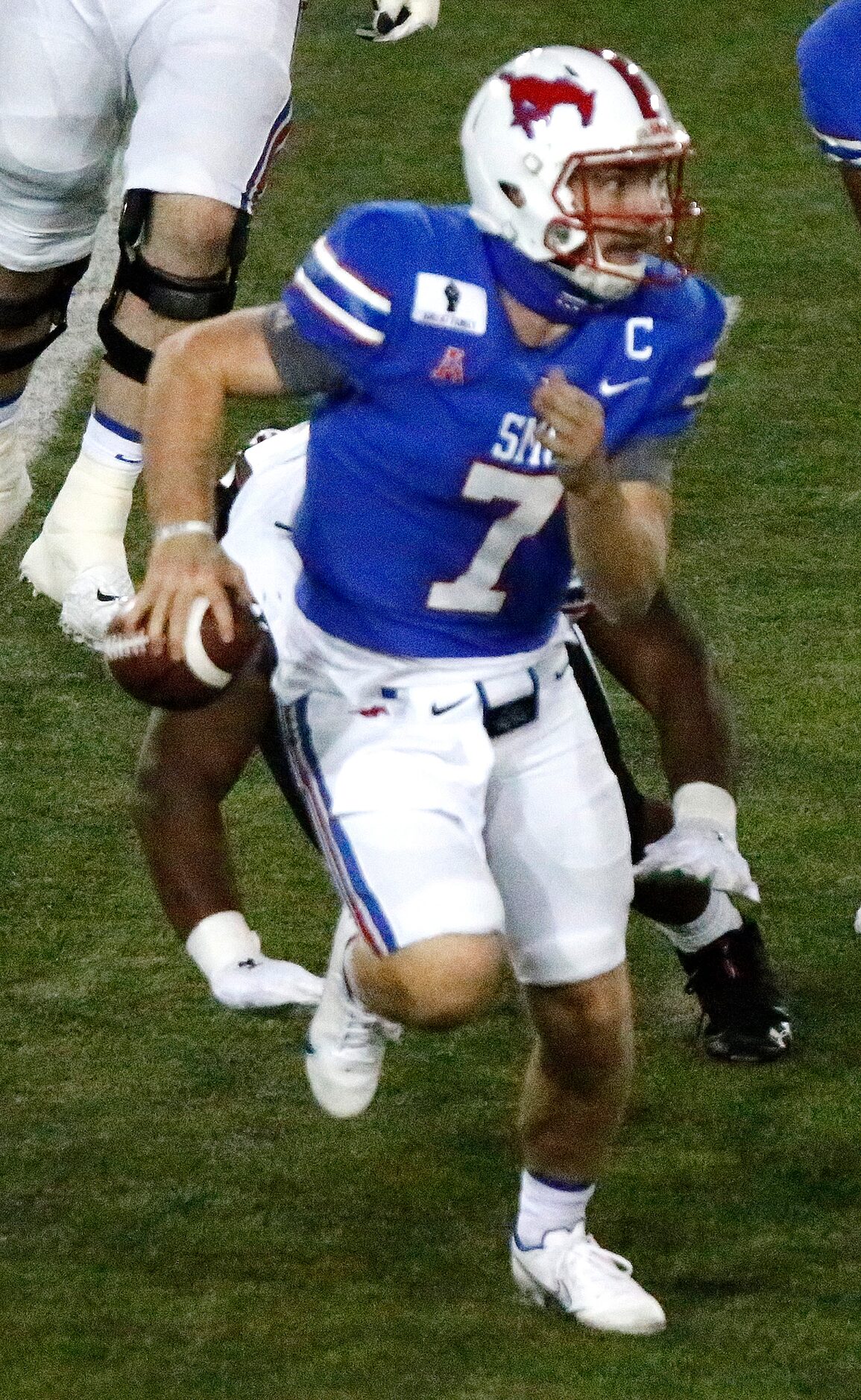 Southern Methodist Mustangs quarterback Shane Buechele (7) escapes pressure from Cincinnati...