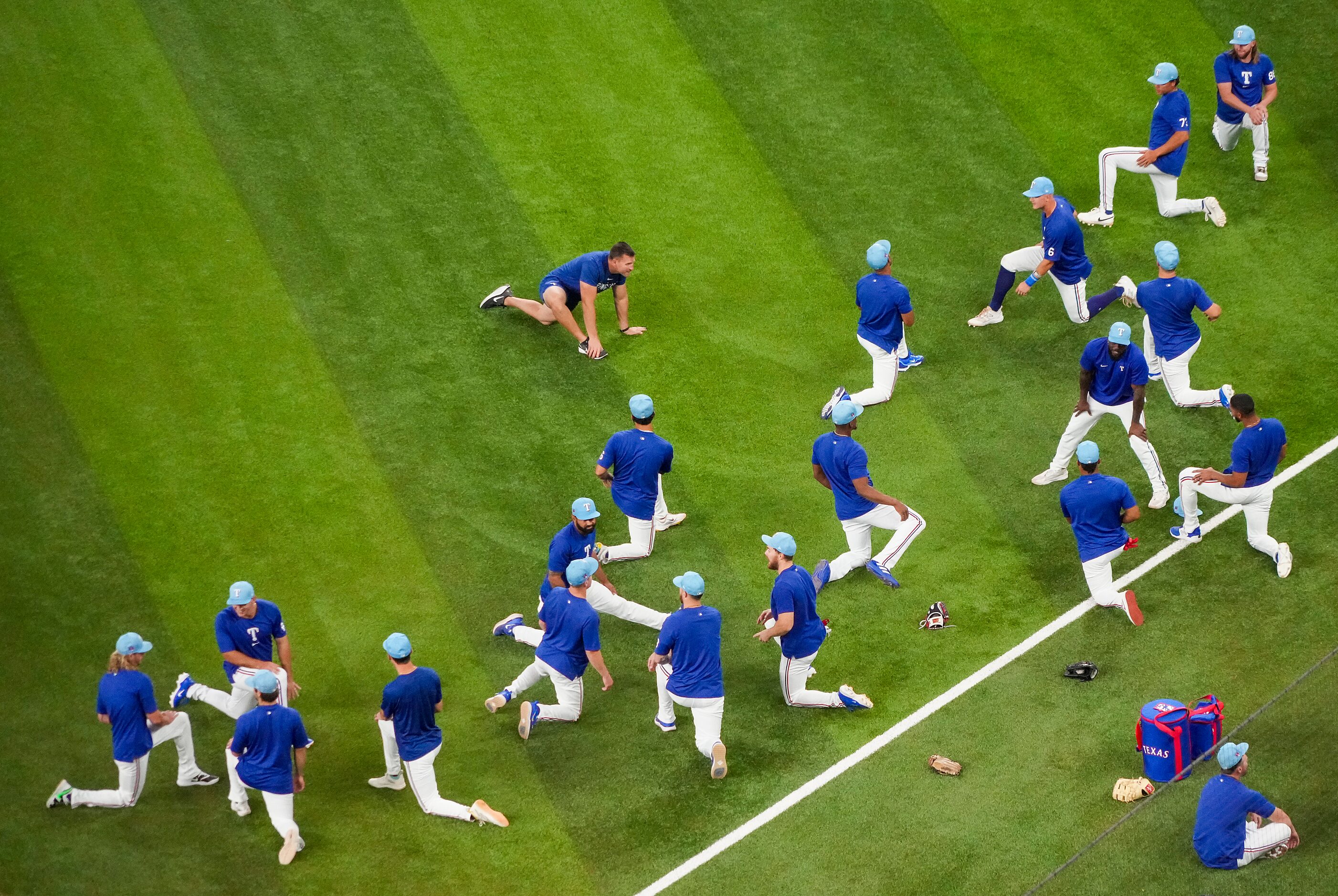 Texas Rangers player stretch on the field before an exhibition baseball game against the...