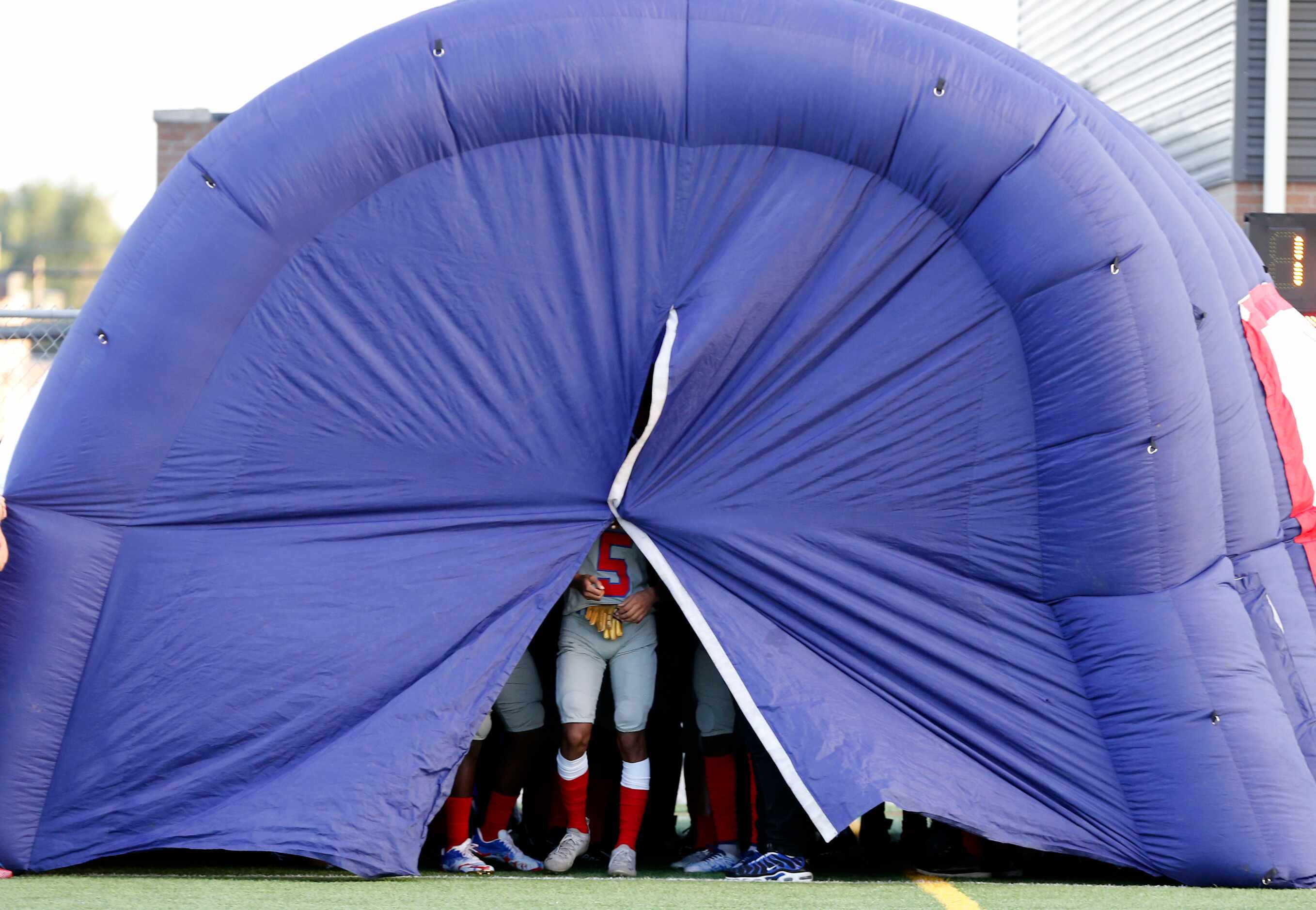 A Spruce team member holds the run-through tunnel shut before the team ran onto the field...