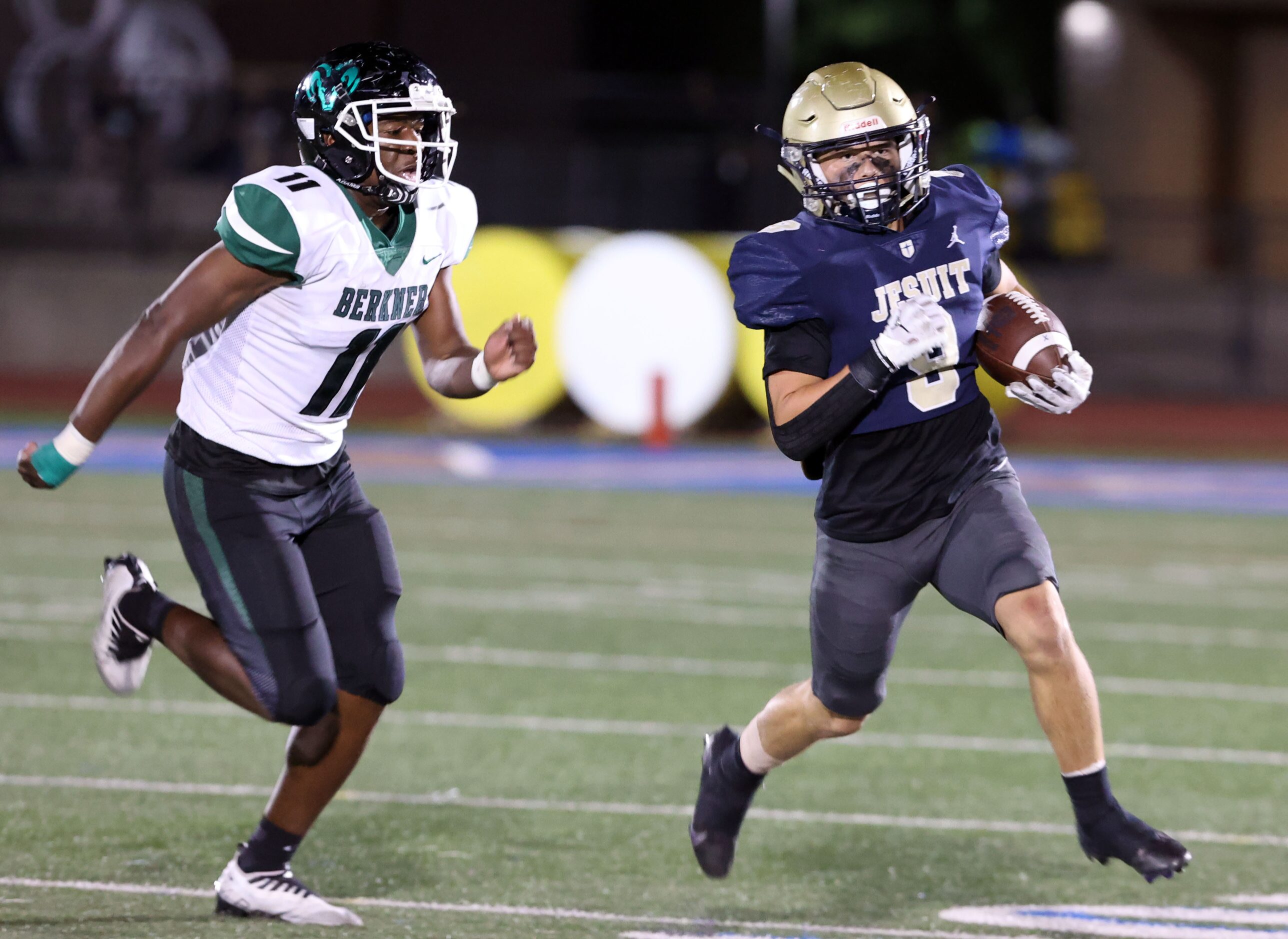 Jesuit’s Will Hanrahan (9) skirts around left end, as Richardson Berkner defender Jett...