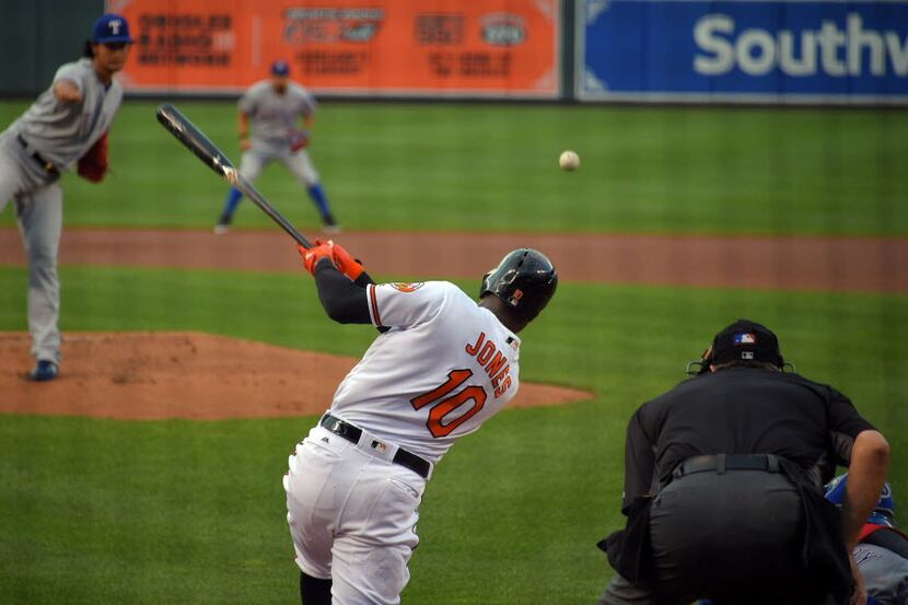 The Baltimore Orioles' Adam Jones (10) connects for a hit against Texas Rangers starting...