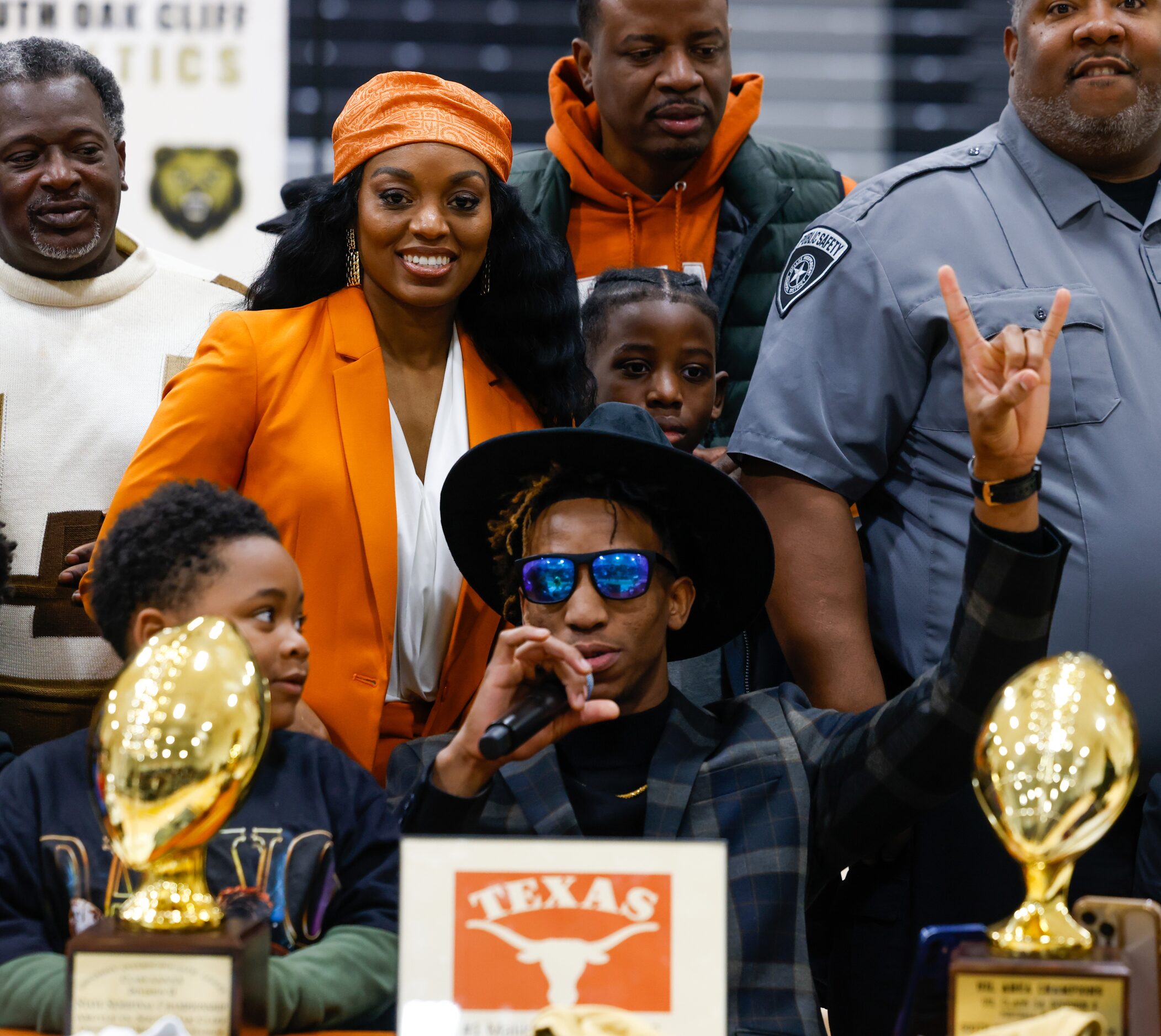 South Oak Cliff football player Manny (Malik) Muhammad (center) raises his hand into a hook...