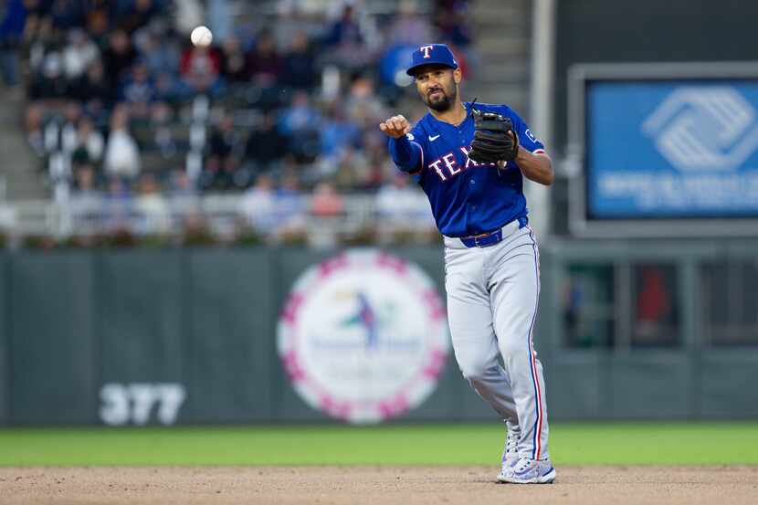 Texas Rangers second baseman Marcus Semien throws to first base to get out Minnesota Twins'...