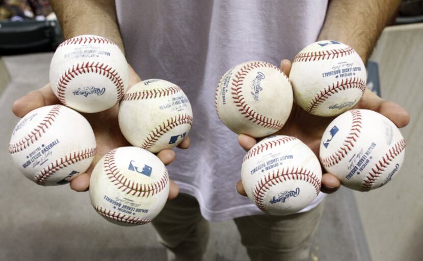Zack Hample holds eight of the 11 balls he collected during Friday's Rangers-Red Sox game.
