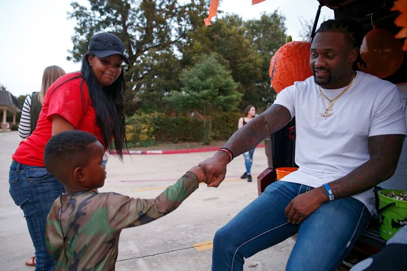 Dallas Cowboys safety Kavon Frazier gives Gage Rodgers, 4 a fist bump as Lola Wilson walks...
