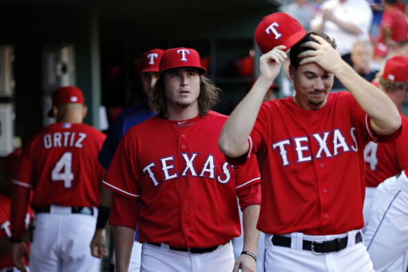 Texas Rangers relief pitchers Luke Jackson (center) and Chi Chi Gonzalez roam the dugout...