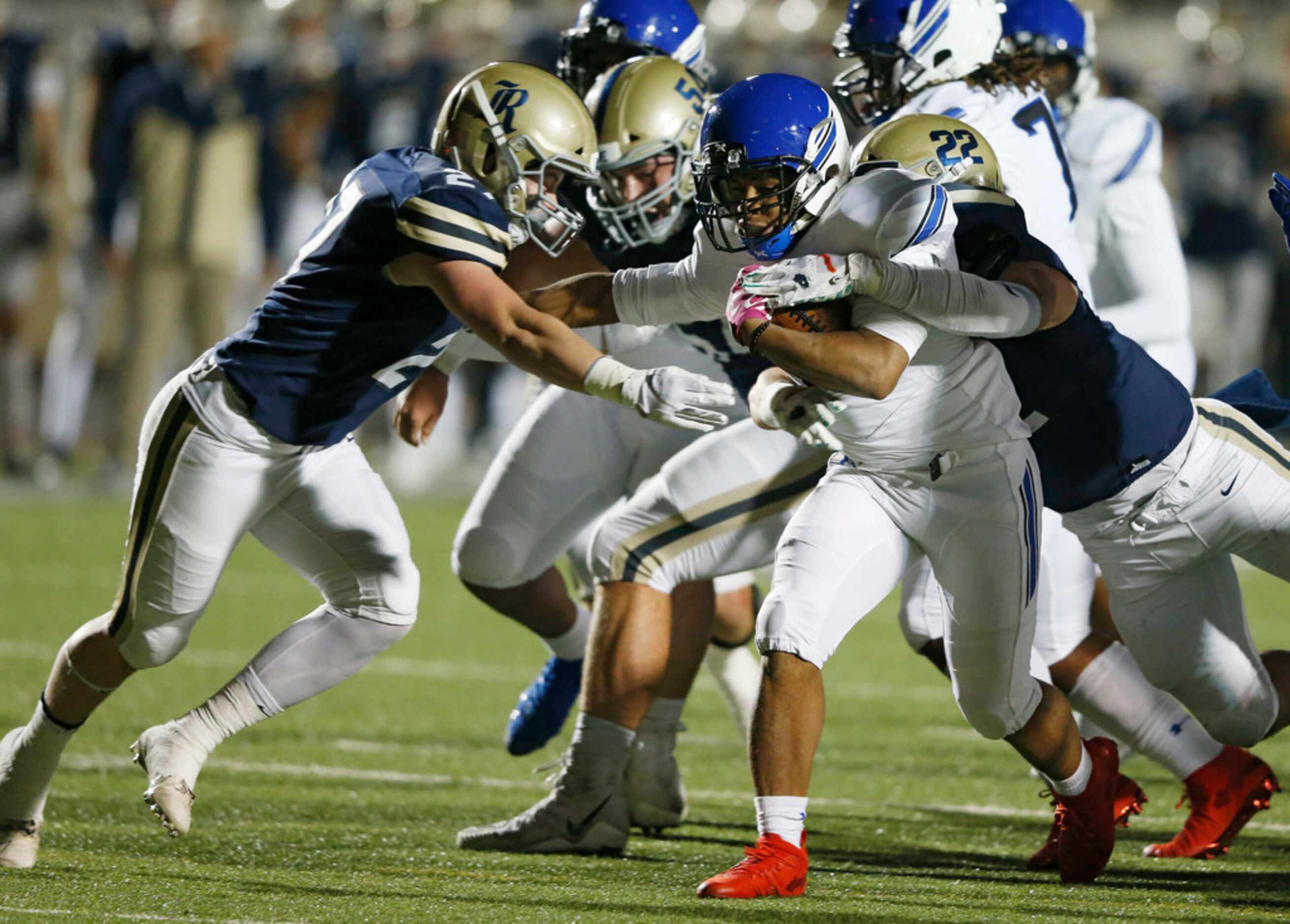 Trinity Christian's Emari Matthews (18) is tackled by Austin Regents Jack Cowden (27) and...