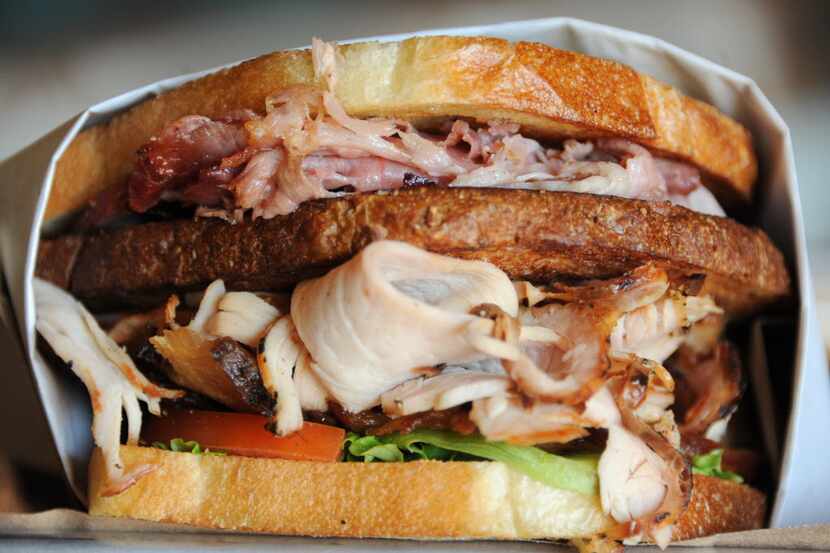 The Club sandwich features bacon, turkey, ham, lettuce, tomato, bacon mayo, and mustard on...