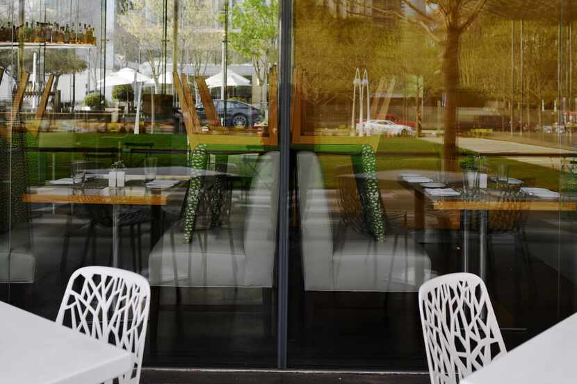Chairs are stacked on top of tables as restaurant Savor in Klyde Warren Park.