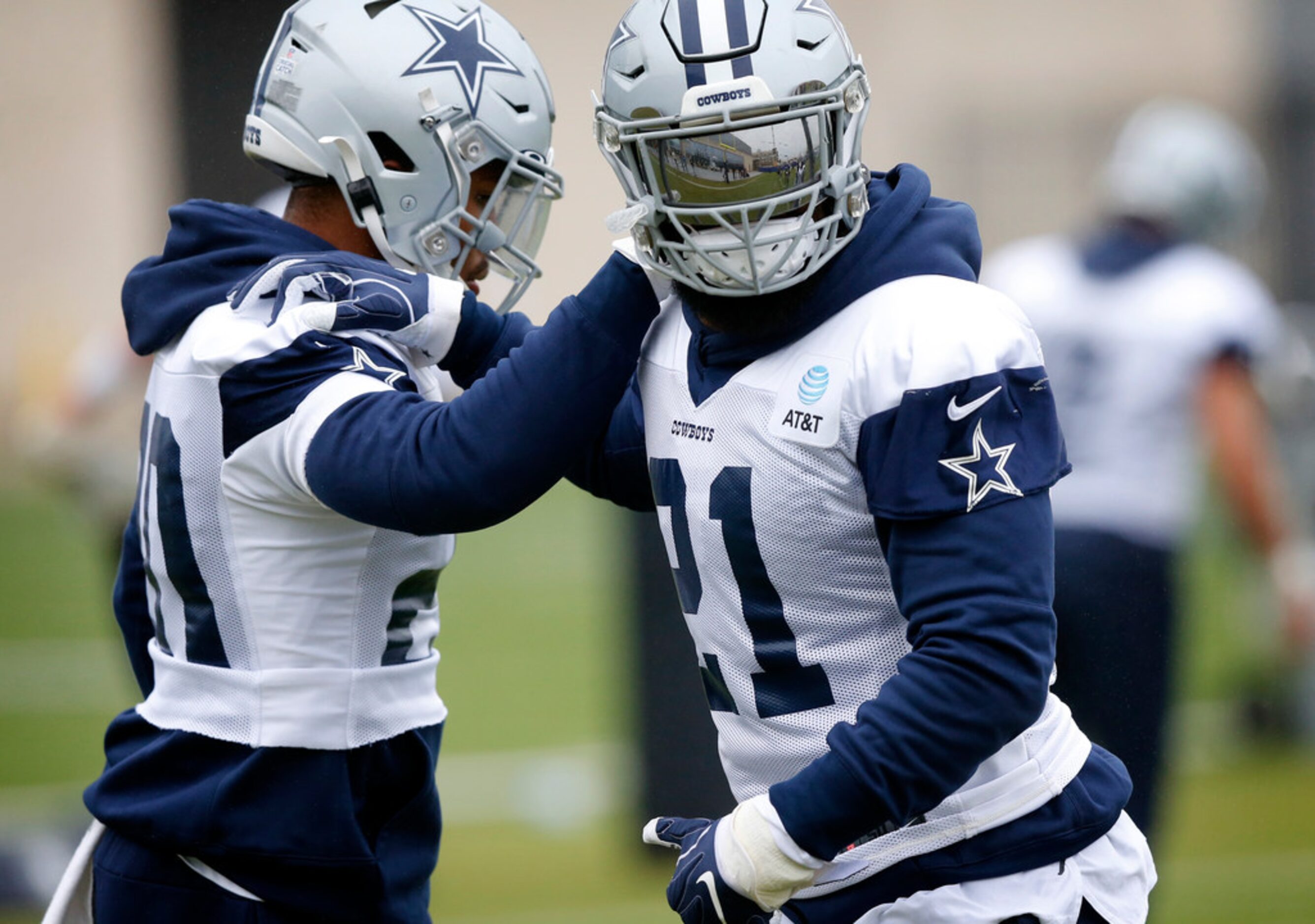 Dallas Cowboys running back Ezekiel Elliott (21) holds fellow running back Tony Pollard (20)...