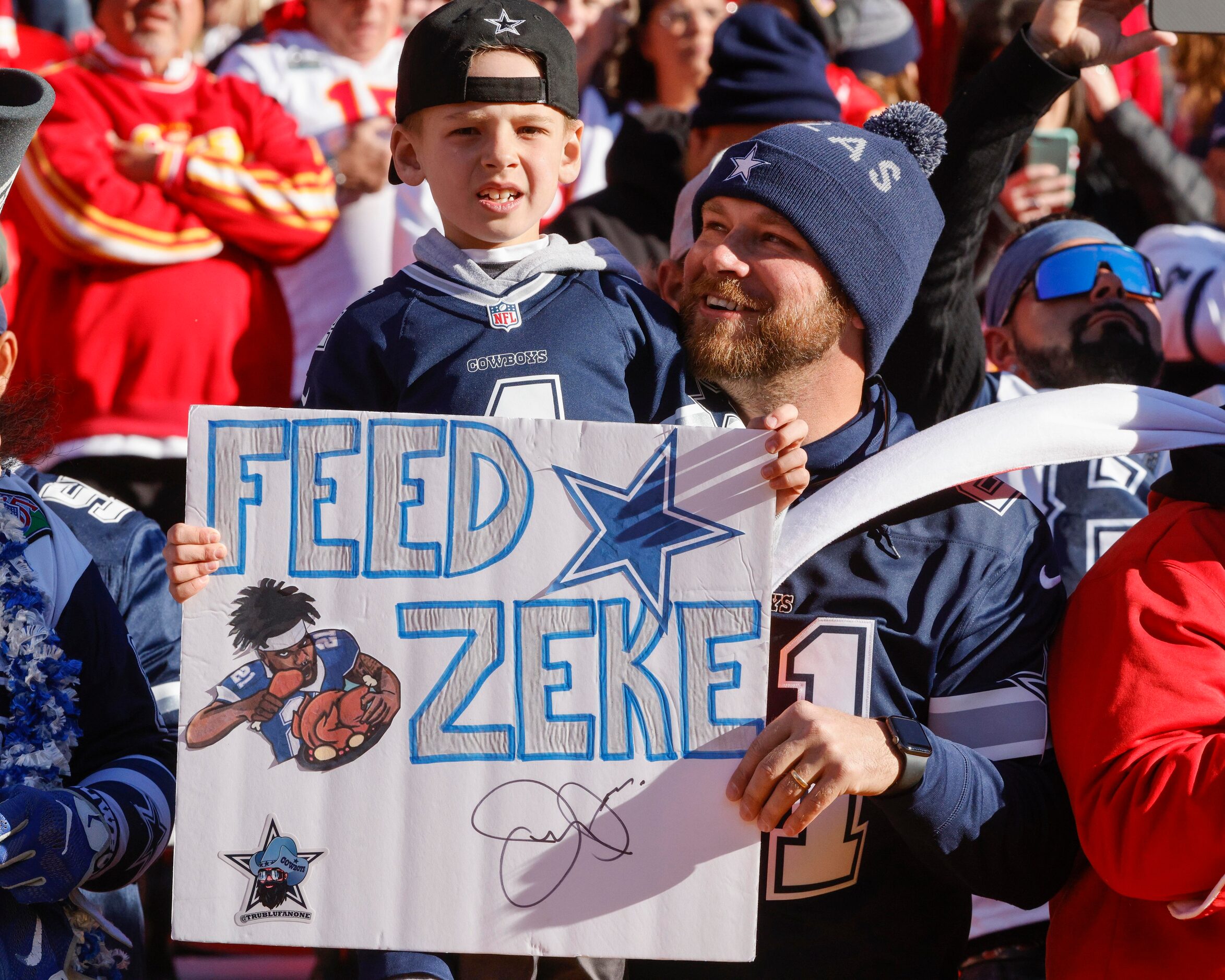 Tommy Selsor, 29, holds his son Parker Selsor, 7, before the first half of an NFL football...