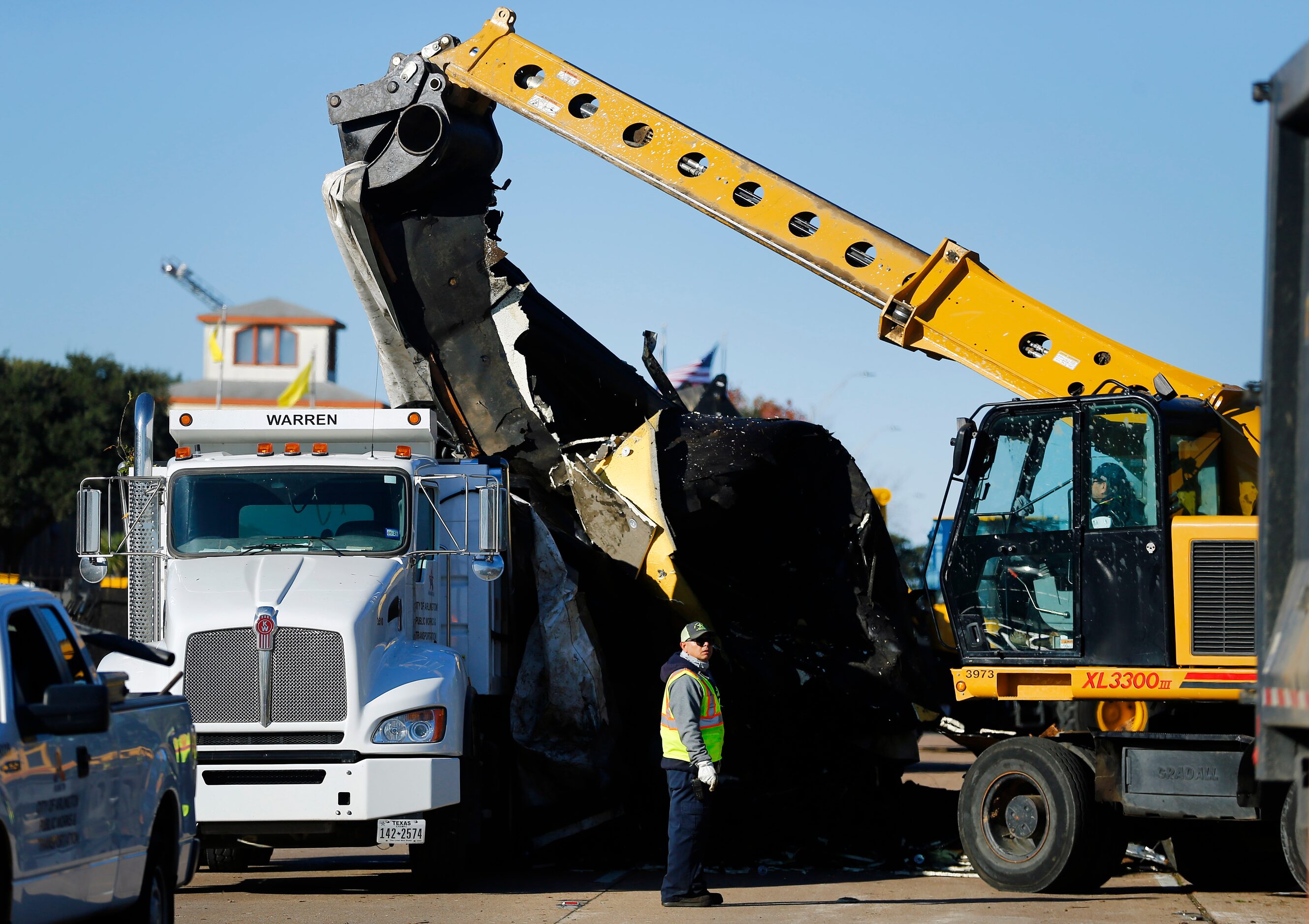 A City of Arlington street crew loads a large piece of roof debris from The Mirage...