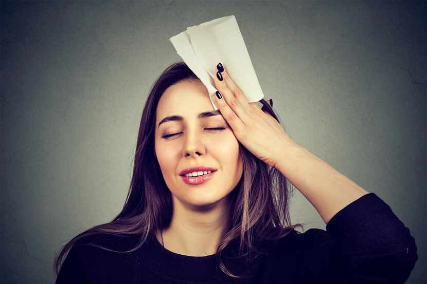 young woman wipes sweat from her forehead with a handkerchief(iStock)
