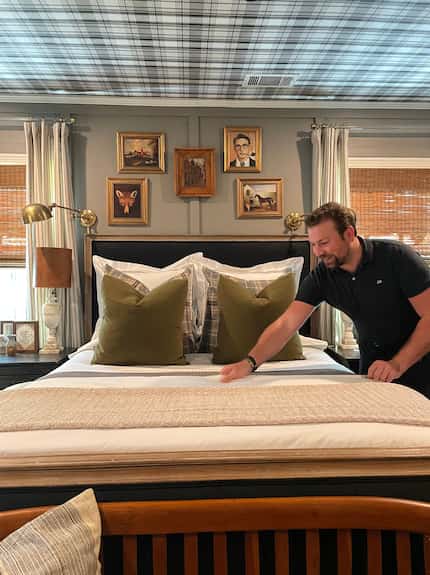 Designer Javier Burkle makes the bed in his own home.