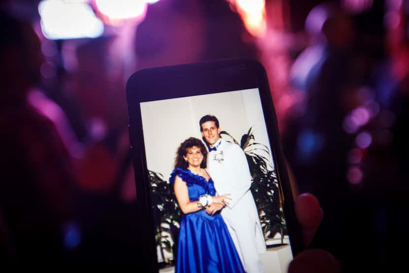 Meryl Evans shows off a prom photo of her with her husband, Paul Evans, during a concert.