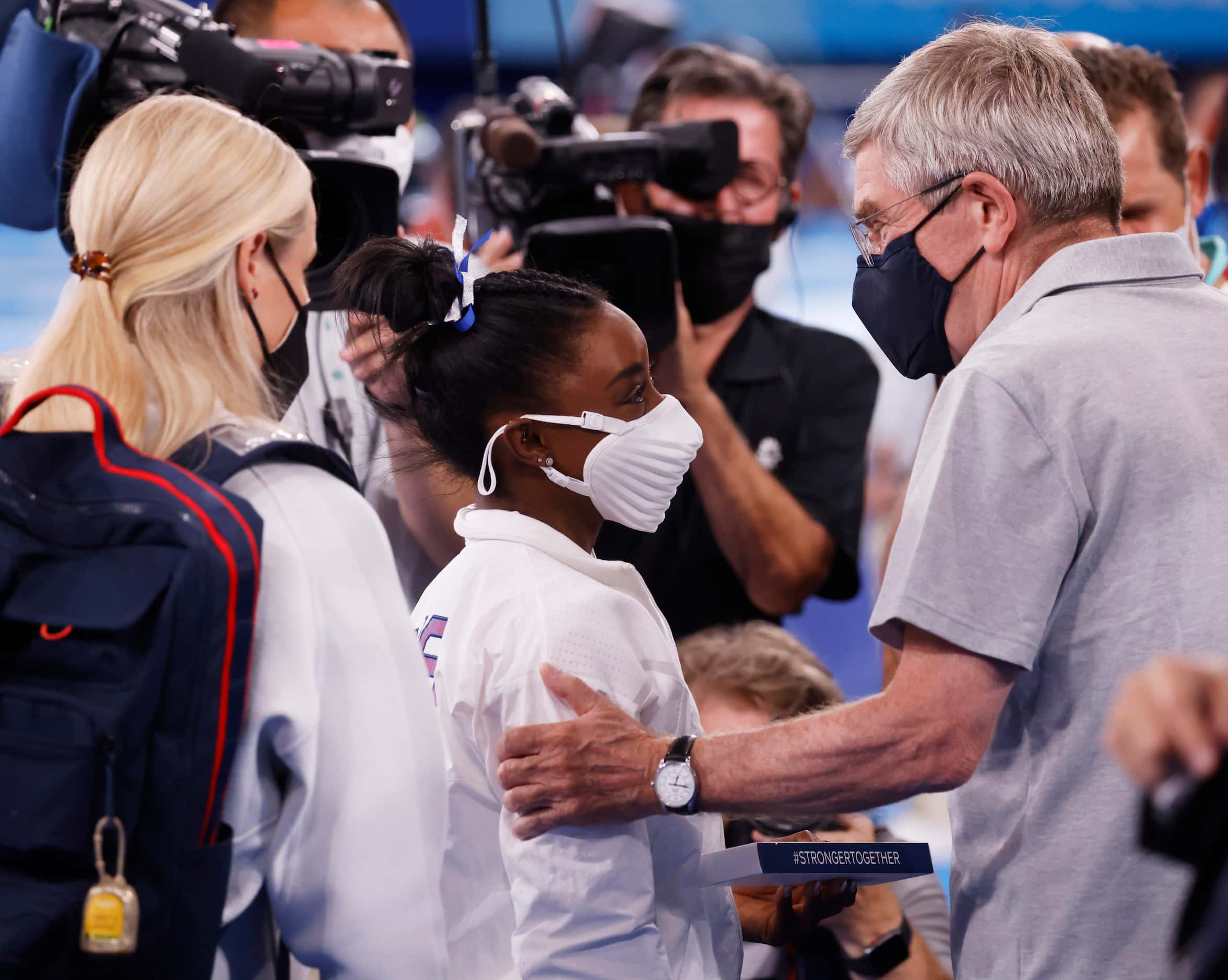 USA’s Simone Biles talks with IOC president Thomas Bach as she makes her way to the medal...