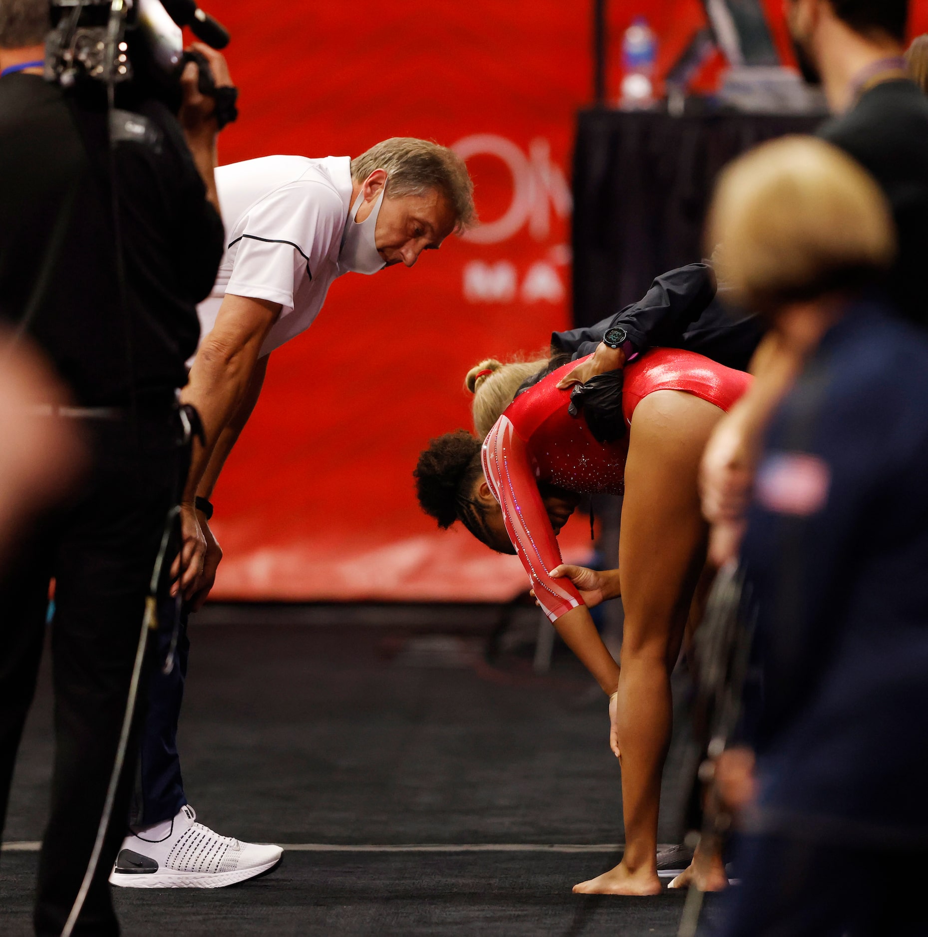 Skye Blakely of WOGA is tended to at the vault station by coach Evgeny Marchenko and medical...