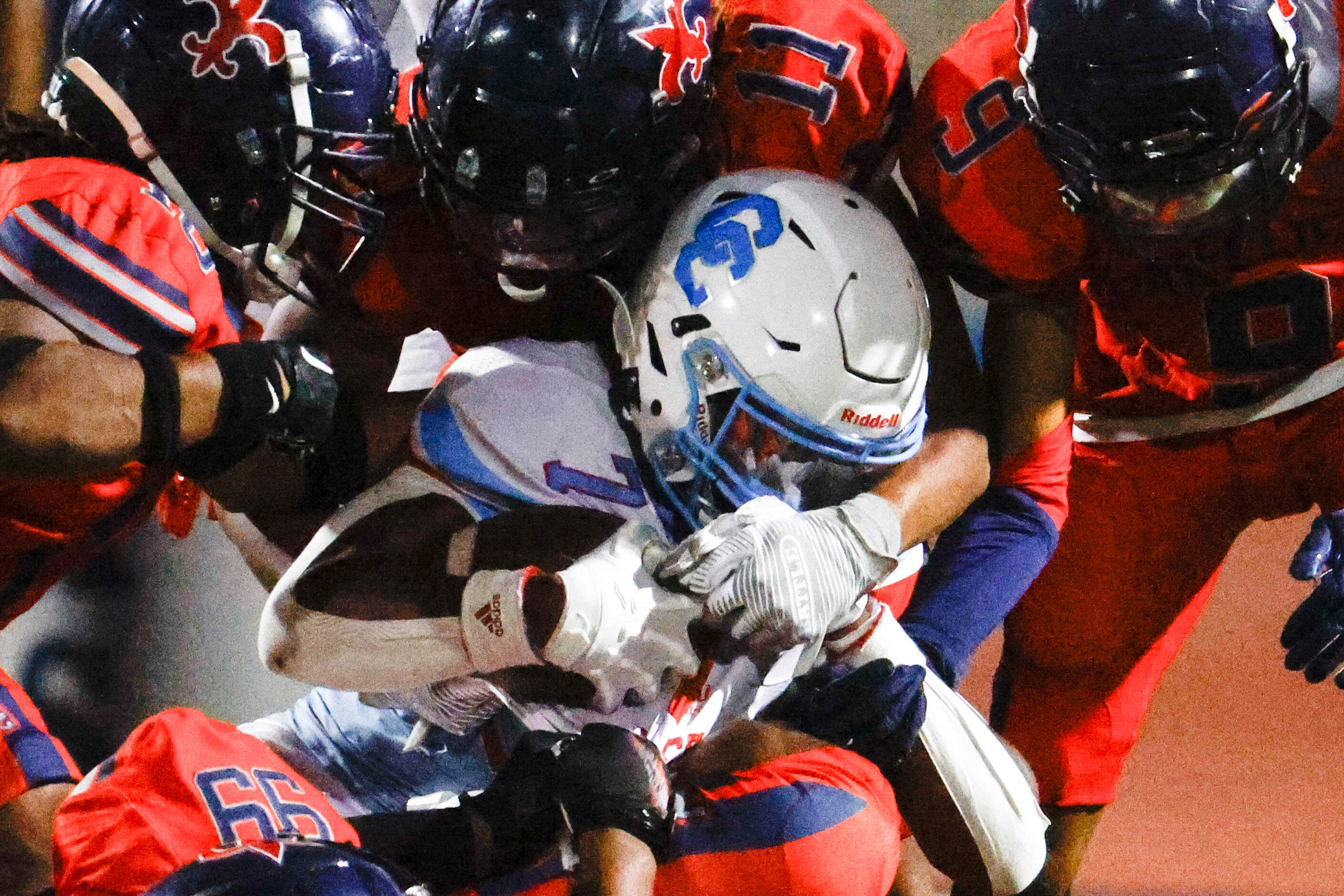 Carter high’s Kaeden Landry gets charged by Kimball high’s players during the first half of...