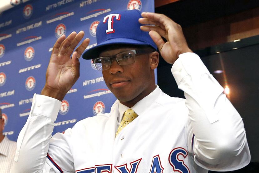 Texas Rangers first-round draft selection Dillon Tate tries on a Rangers jersey and cap...