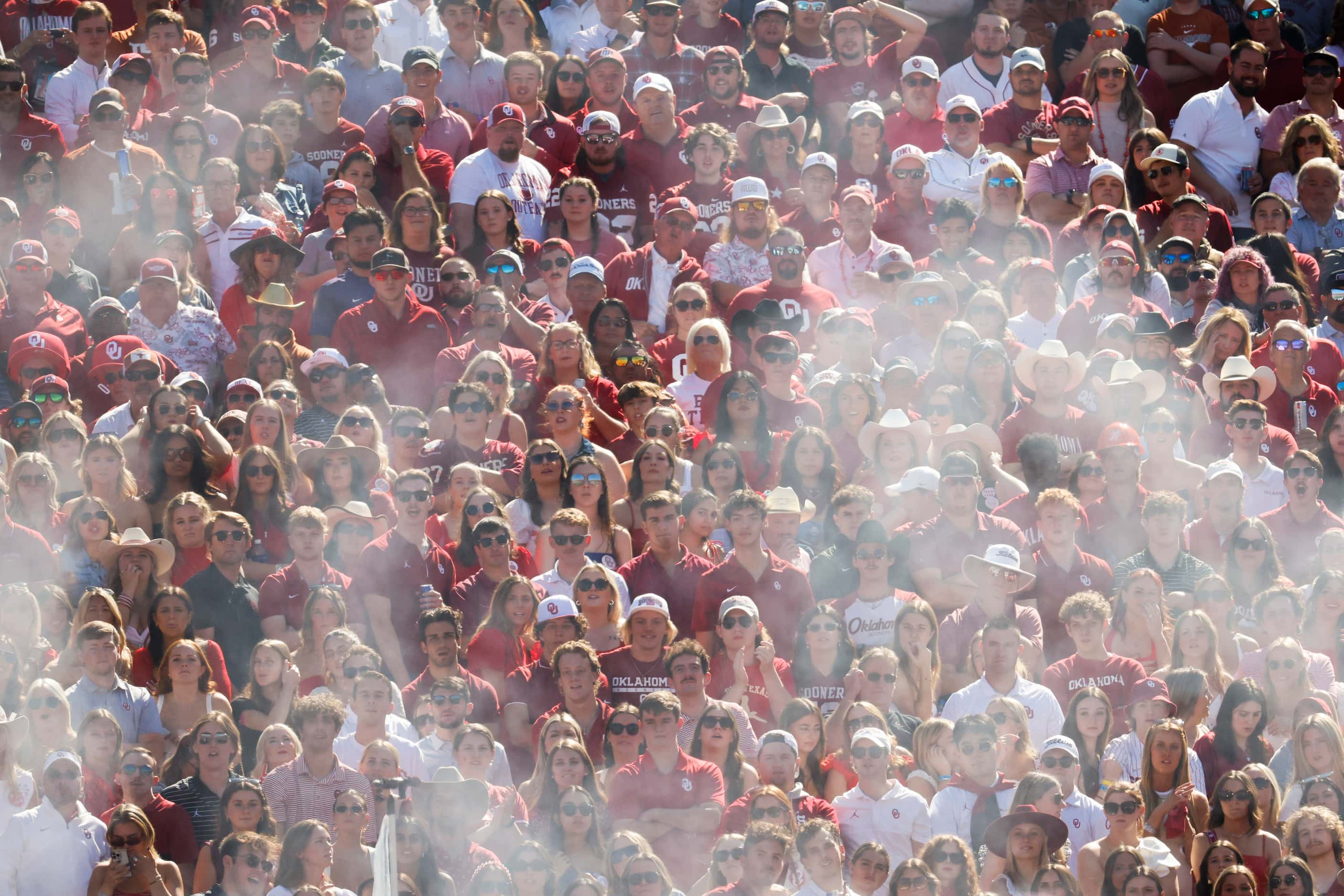 Oklahoma fans seen through a circle of smoke from the canon during the Red River Rivalry at...