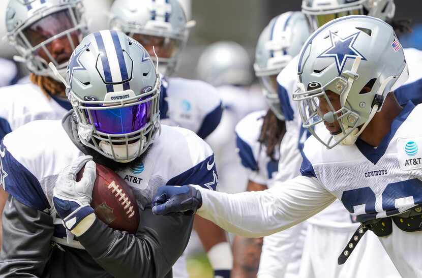 Dallas Cowboys running back Tony Pollard (20) tries to punch the ball away from running back...
