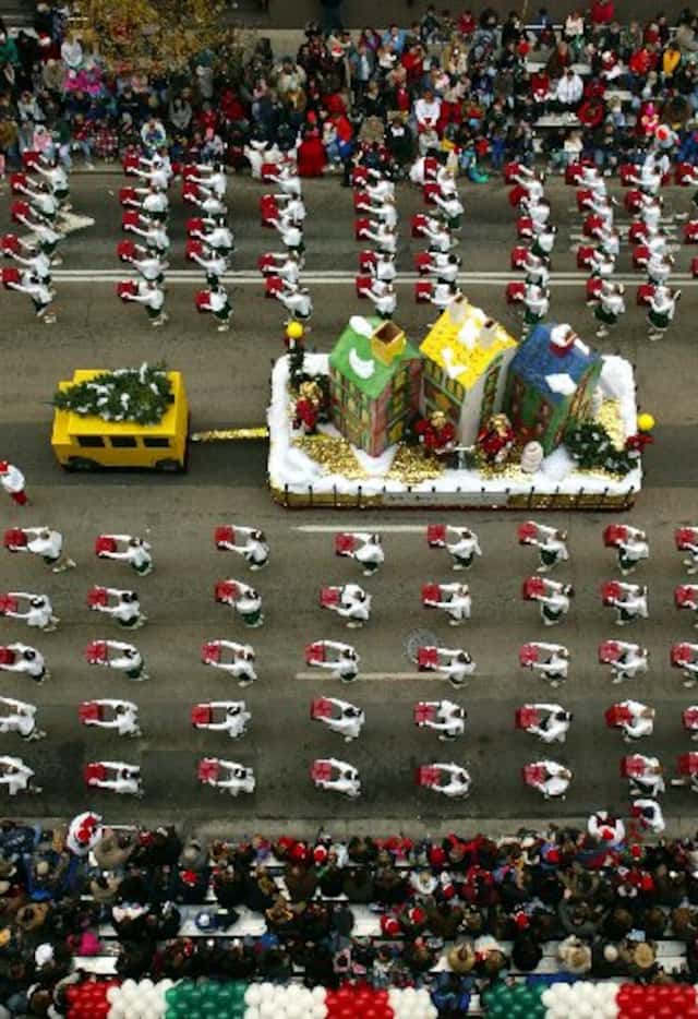 The World of Neiman Marcus float is escorted down Commerce Street by the Naaman Forest High...