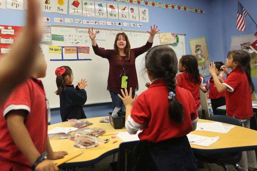 Kindergarten teacher Myka Moseley works with her students during morning class at the...