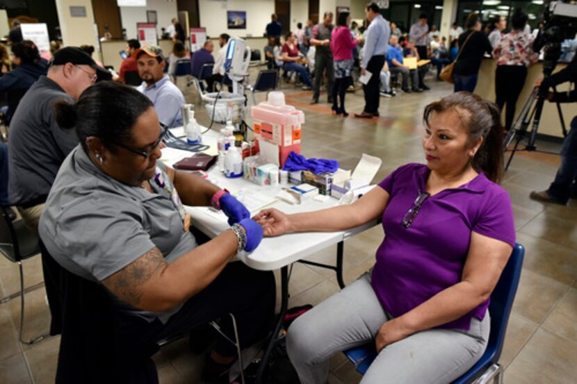 Un especialista realiza una prueba de sangre a Justina Saldaña, de Fort Worth. BEN TORRES/AL...