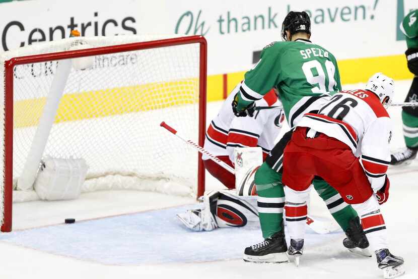 The shot by Dallas Stars left wing Patrick Sharp slides past teammate Jason Spezza (90) and...