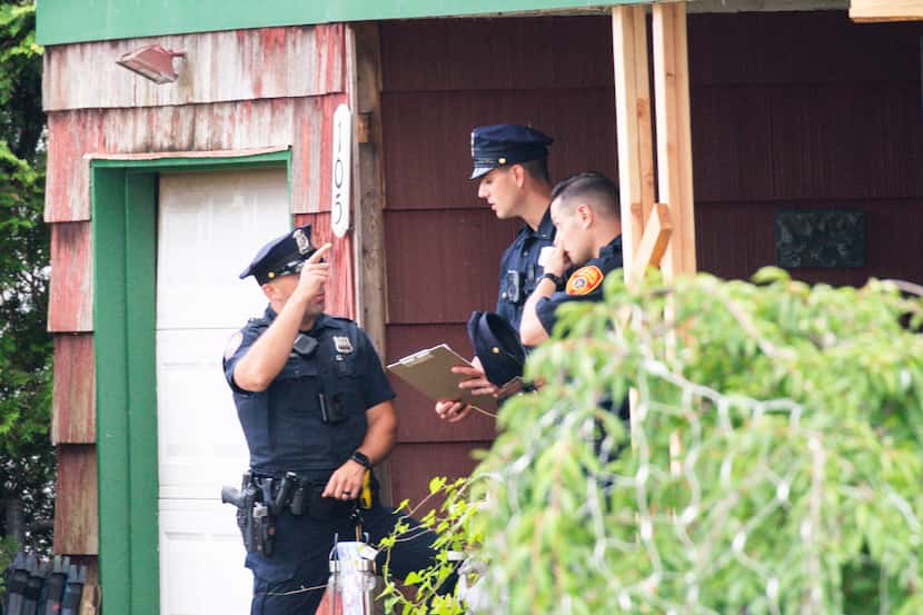 Police officers arrive to the house where a suspect has been taken into custody on New...