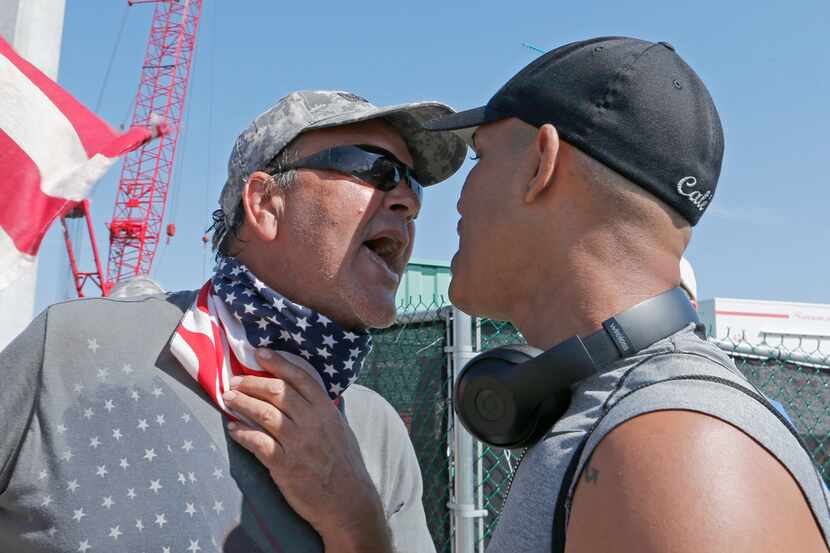 A gun-rights advocate (left) exchanges heated words with demonstrator Eric Cauley as Cauley...