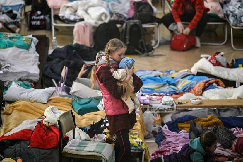 A girl holds her sibling in a temporary shelter for Ukrainian refugees in a school in...