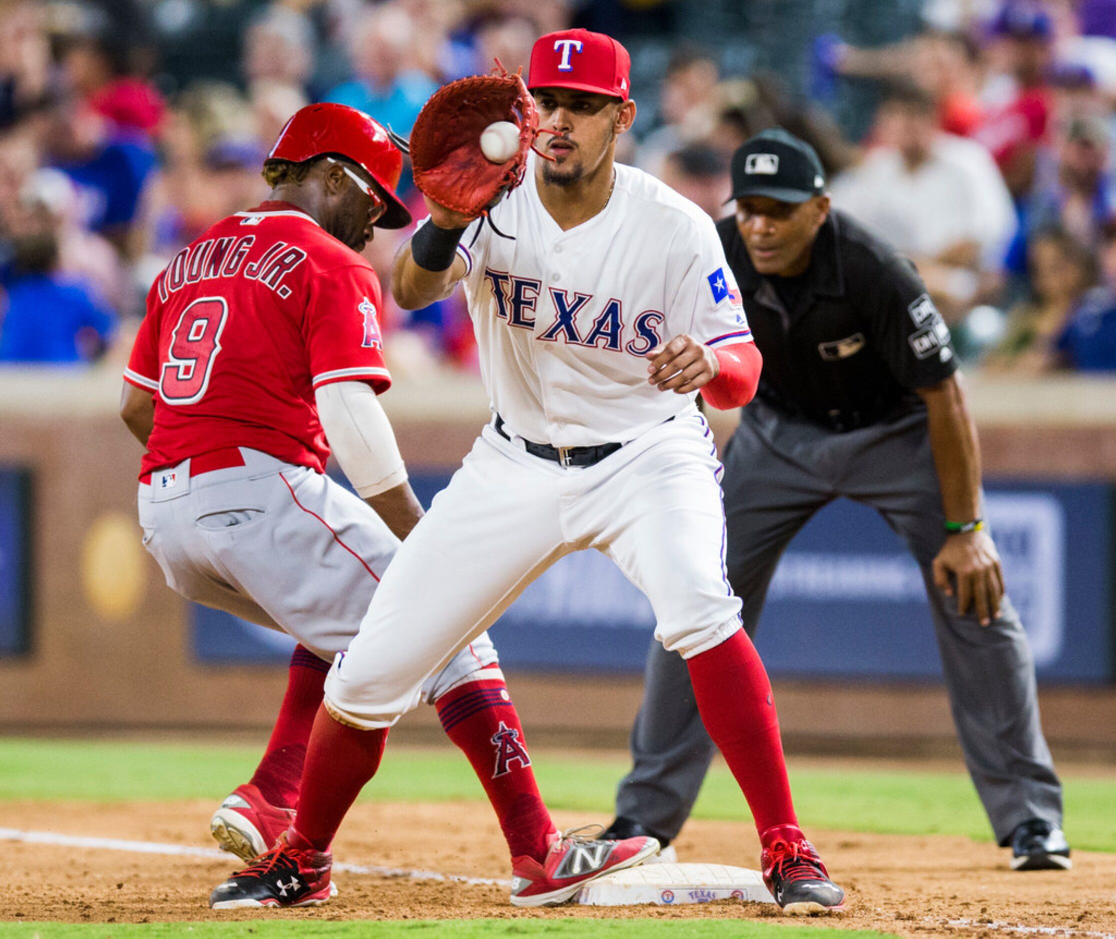 Texas Rangers out fielder Joey Gallo (13) catches a throw to first as Los Angeles Angels...