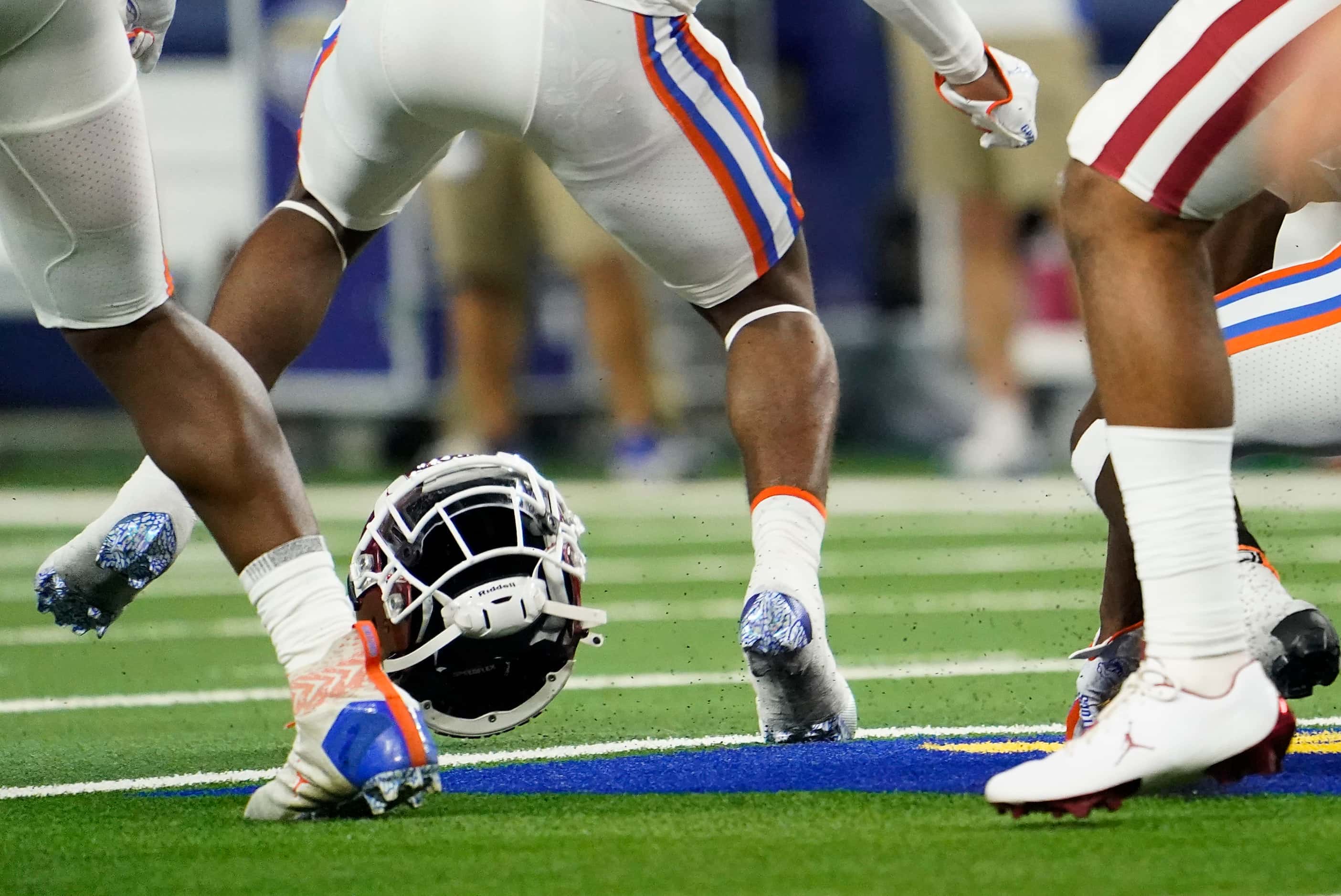 Oklahoma running back Rhamondre Stevenson’s helmet flies out of a pile of players during the...