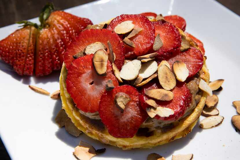 Almond chaffel is topped with almond butter and sliced berries on Wednesday, April 21, 2021,...