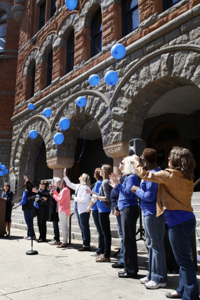 Eleven balloons are released in front of the Old Red Courthouse in memory of 11 children...