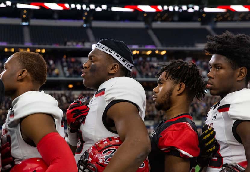 Cedar Hill players pray during the National Anthem prior to the game against Denton Guyer in...