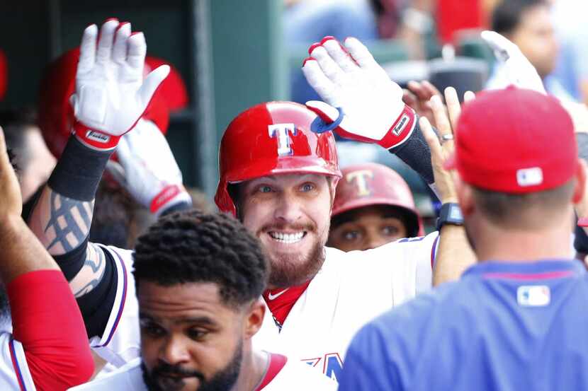 Texas Rangers left fielder Josh Hamilton (32) celebrates his 3-run home run in the dugout in...