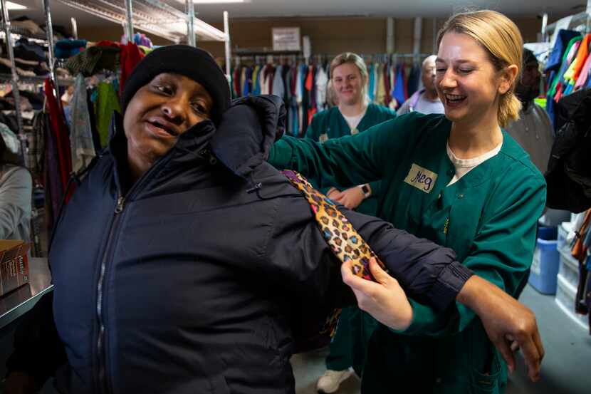 Baylor Nursing student Carol Tipp helps Cecelia Nash put on her new backpack in the...