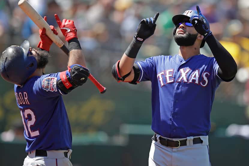 Texas Rangers' Nomar Mazara, right, celebrates with Rougned Odor (12) after hitting a home...
