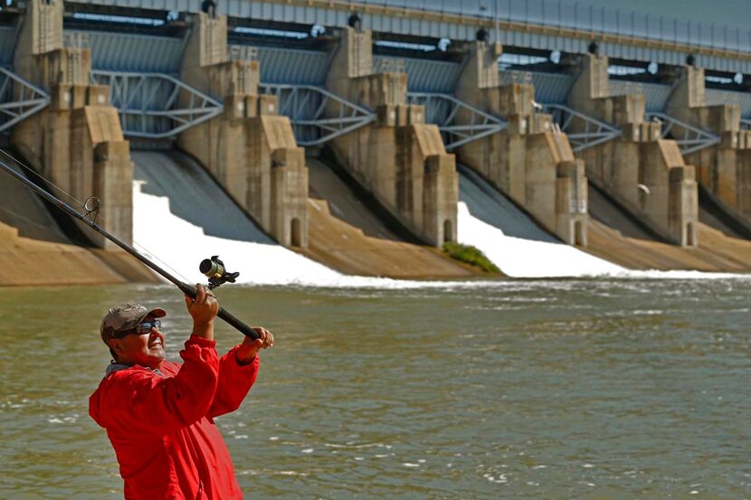 
Antonio Pinon casts into the spillway of Lavon Lake to catch fish after the Army Corps of...