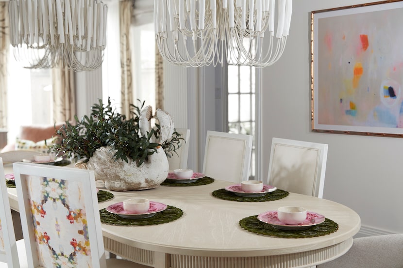 This room designed by Elizabeth Ryan features Arteriors "Tilda" chandeliers that hang over...