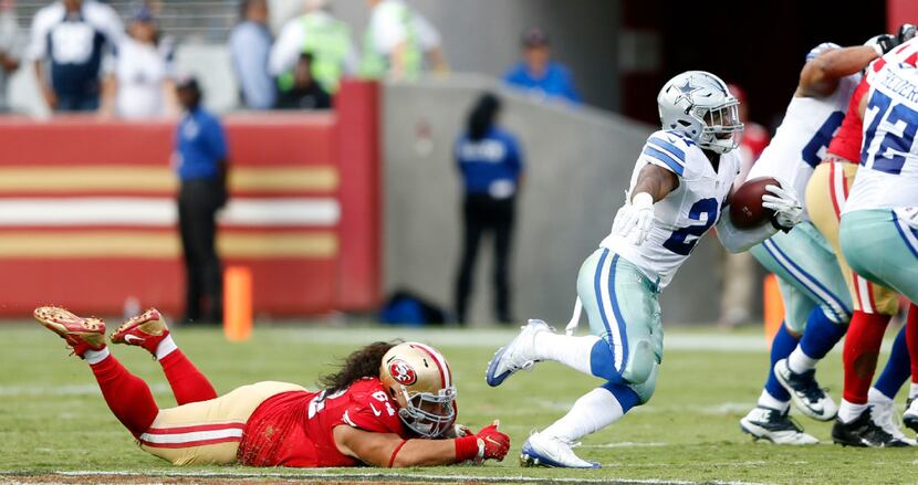 Dallas Cowboys running back Ezekiel Elliott (21) evades San Francisco 49ers nose tackle Mike...