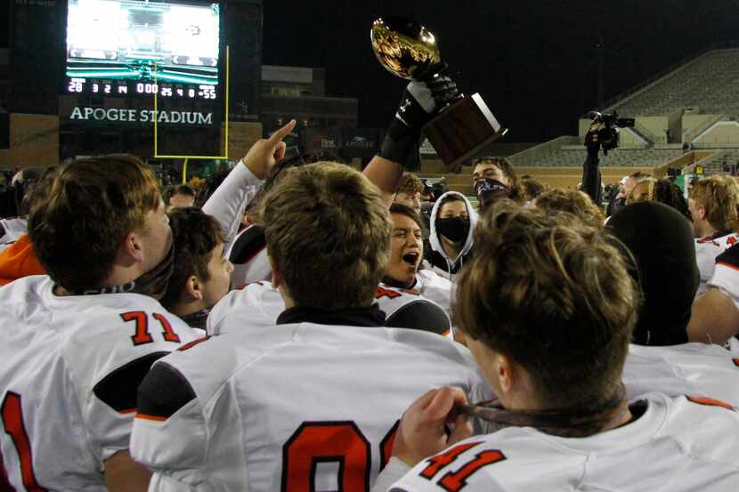 Aledo Bearcats players celebrate with the Class 5A Division ll championship trophy presented...