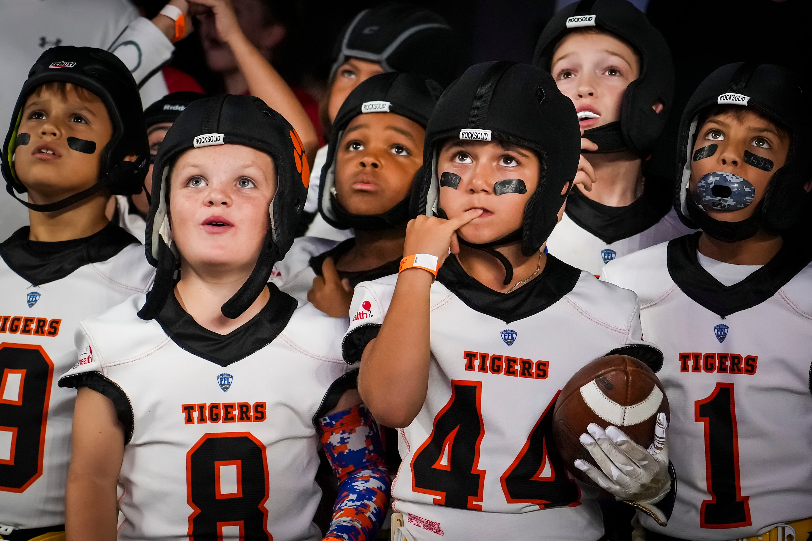 A group of youth flag football players waits in the tunnel to go on the field for halftime...