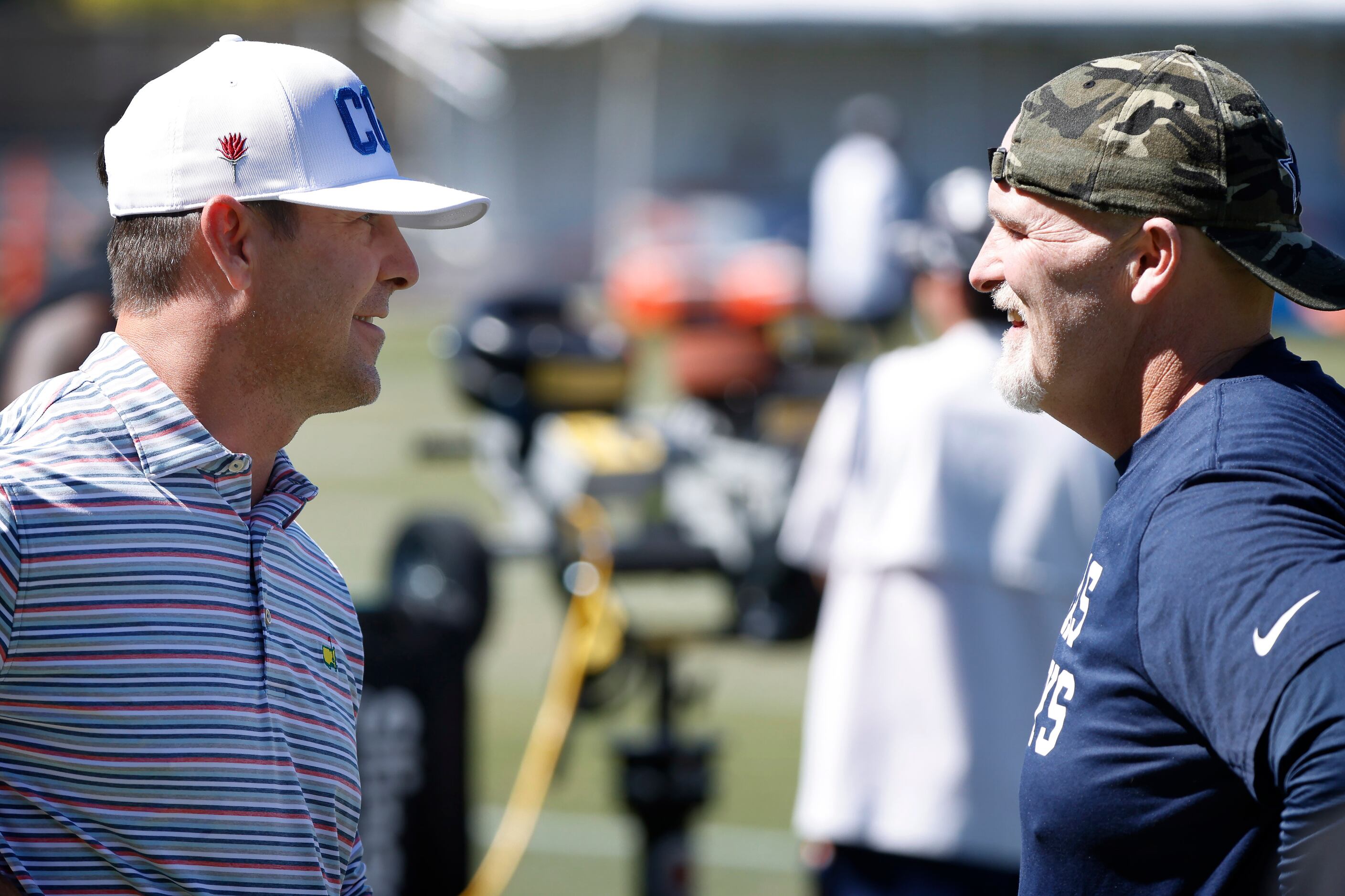 Dallas Cowboys defensive coordinator Dan Quinn (right) visits with Denver Broncos general...