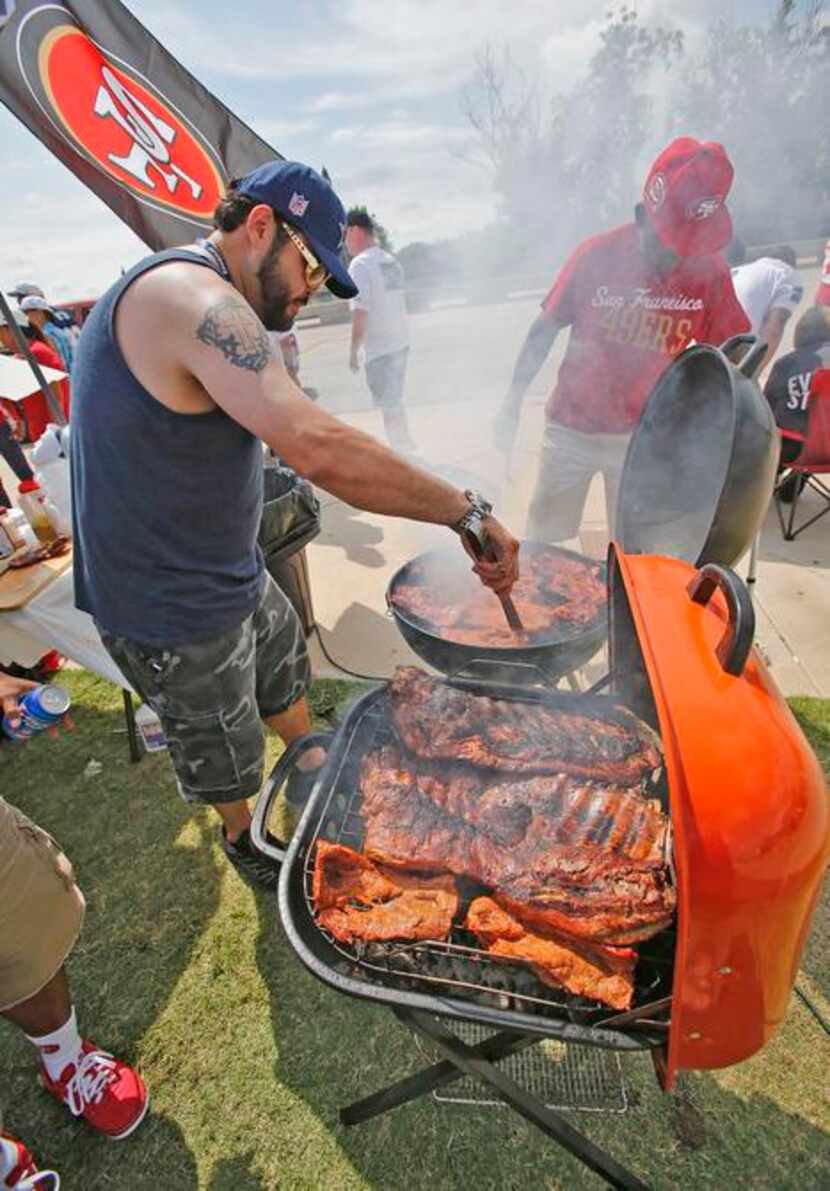 
Rey Morales of Plano mans the grill as he and his friends await the start of the game.
