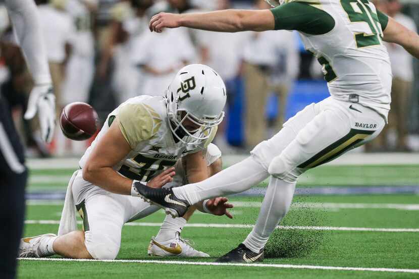 Baylor Bears place kicker Connor Martin (96) kicks the ball from punter Drew Galitz (36) to...